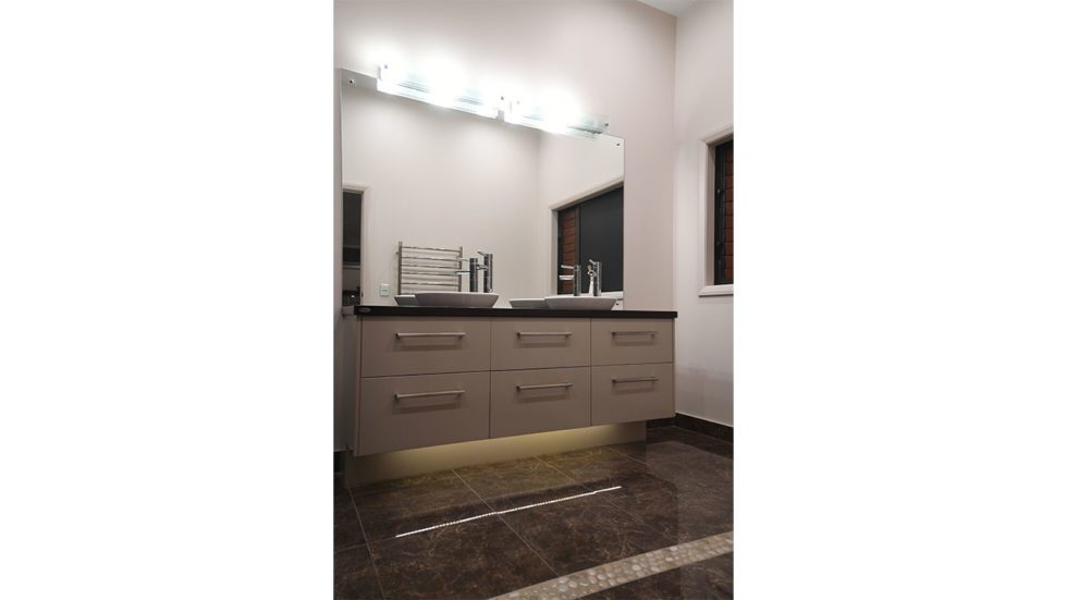 Custom twin basin bathroom featuring vanity lights and LEDs